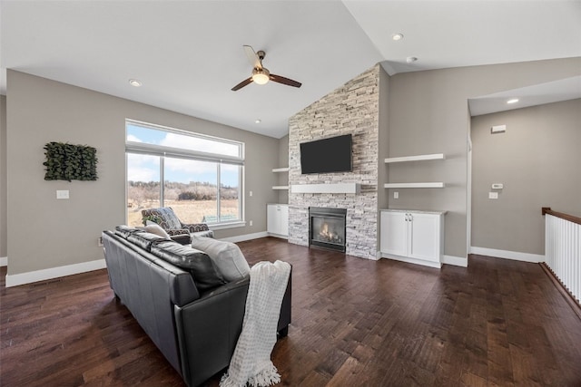 living room featuring dark hardwood / wood-style flooring, ceiling fan, a stone fireplace, and built in shelves