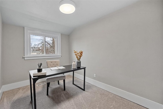 carpeted home office featuring vaulted ceiling