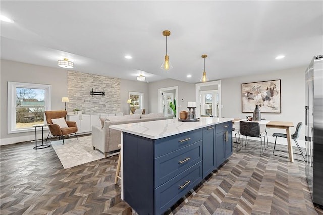 kitchen with light stone counters, blue cabinets, decorative light fixtures, and a kitchen island