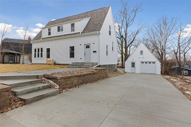 view of front of home featuring a garage and an outbuilding