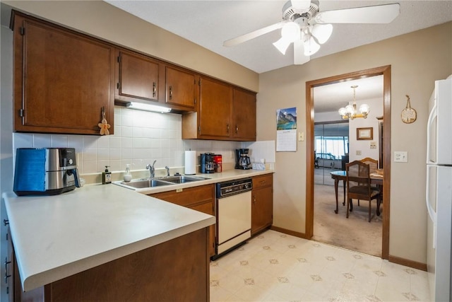 kitchen featuring sink, white appliances, ceiling fan with notable chandelier, hanging light fixtures, and decorative backsplash