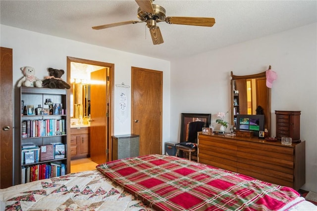 bedroom featuring ceiling fan, ensuite bath, and a textured ceiling