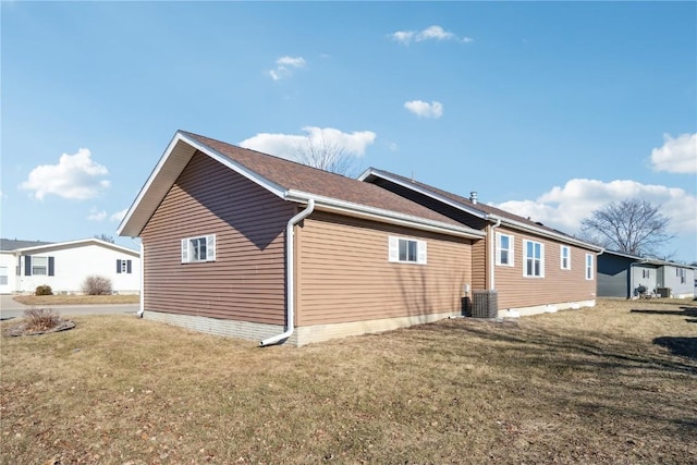 view of home's exterior with cooling unit and a lawn