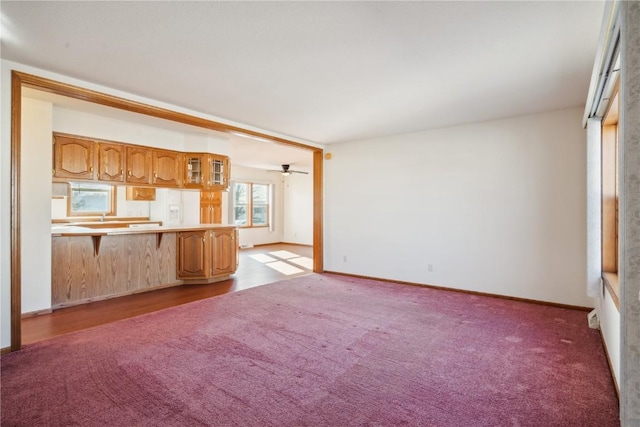 unfurnished living room with light colored carpet and ceiling fan