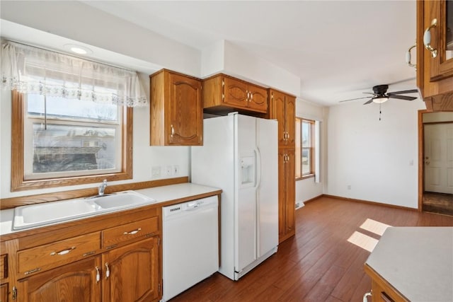 kitchen with dark hardwood / wood-style flooring, sink, ceiling fan, and white appliances