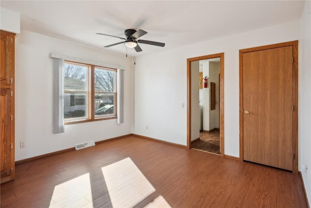 unfurnished bedroom with ceiling fan and wood-type flooring