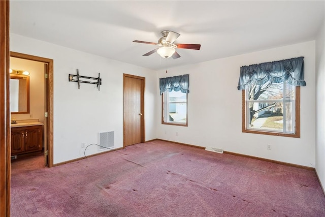 unfurnished bedroom featuring ceiling fan, ensuite bath, carpet flooring, and a closet