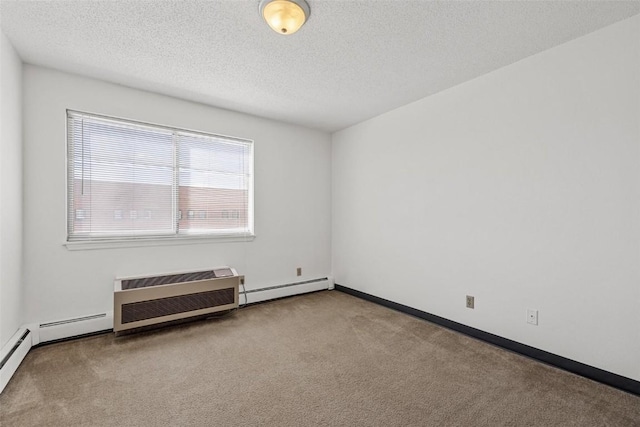 spare room featuring an AC wall unit, a baseboard heating unit, a textured ceiling, and carpet flooring