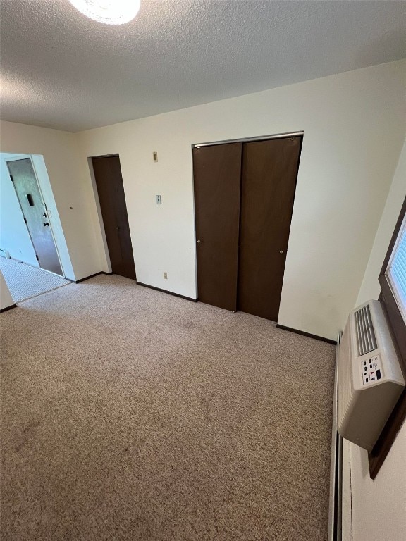 carpeted spare room with a textured ceiling