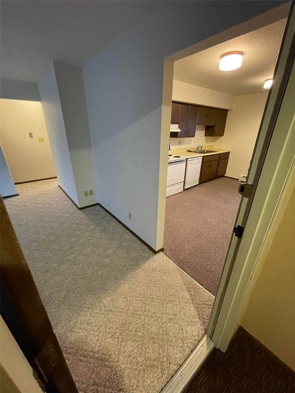 interior space with light carpet, sink, and a textured ceiling