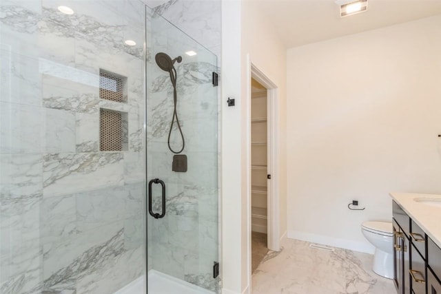 bathroom with vanity, toilet, and a shower with shower door