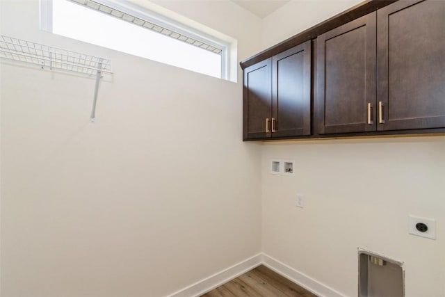 laundry room with electric dryer hookup, hookup for a washing machine, cabinets, and hardwood / wood-style flooring