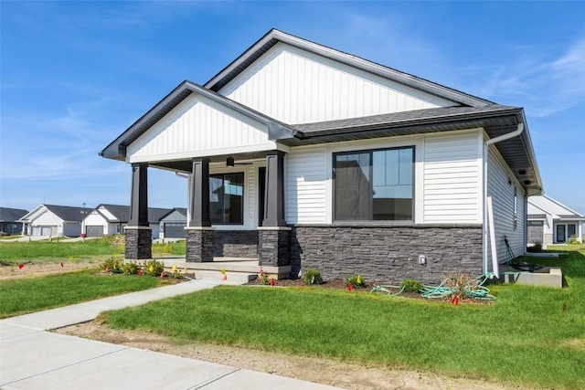 view of front of house with covered porch and a front lawn