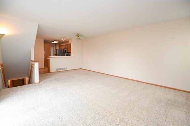 unfurnished living room featuring light carpet