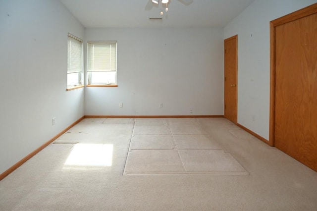 empty room featuring ceiling fan and light carpet