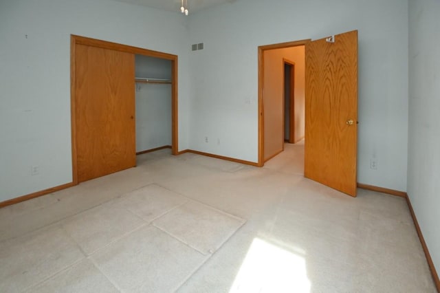 unfurnished bedroom with light carpet and a closet