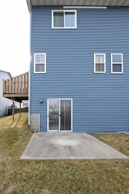 rear view of house with a patio and a yard