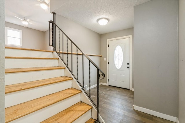 entryway featuring dark wood-type flooring and a textured ceiling