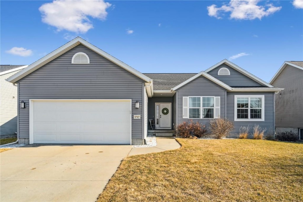 ranch-style home featuring a garage and a front yard