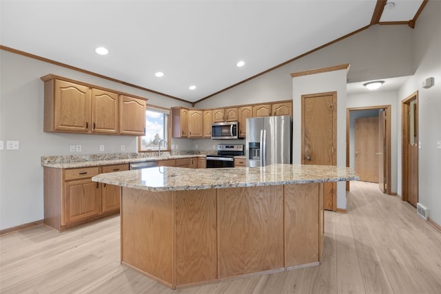 kitchen featuring crown molding, appliances with stainless steel finishes, and a center island