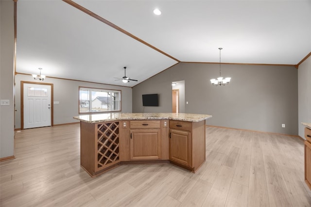 kitchen featuring pendant lighting, a center island, light stone counters, and light hardwood / wood-style flooring