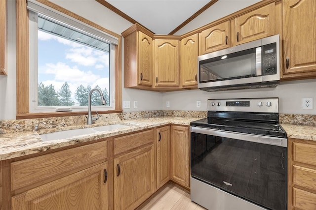 kitchen with light stone counters, stainless steel appliances, and sink