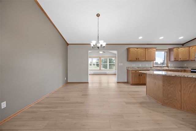 kitchen featuring decorative light fixtures, a chandelier, crown molding, light stone countertops, and light wood-type flooring