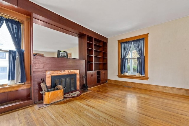 living room with built in features and light wood-type flooring