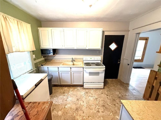 kitchen with white cabinetry, white electric range oven, and sink