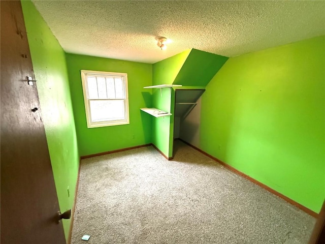 bonus room with a textured ceiling and carpet flooring