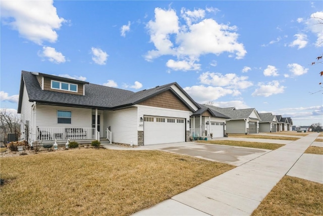 view of front of home featuring a garage, covered porch, and a front lawn