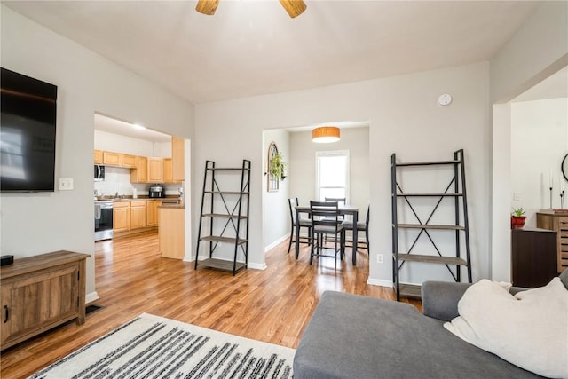 living room featuring ceiling fan and light wood-type flooring