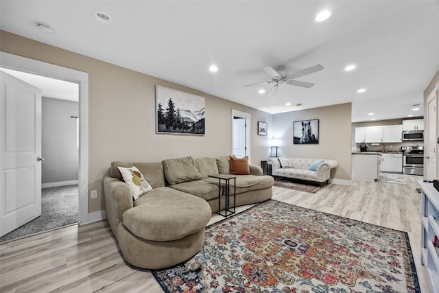 living room with light hardwood / wood-style floors and ceiling fan