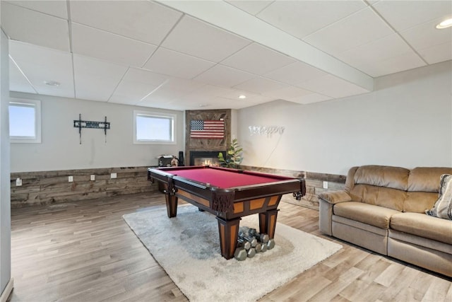 game room featuring a drop ceiling, hardwood / wood-style flooring, a fireplace, and pool table