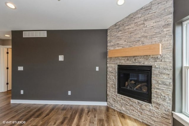 unfurnished living room with lofted ceiling, dark wood-type flooring, and a fireplace