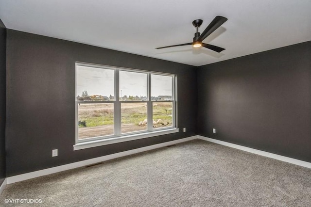 spare room featuring ceiling fan and carpet floors