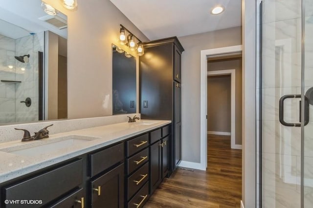 bathroom featuring vanity, hardwood / wood-style flooring, and a shower with door