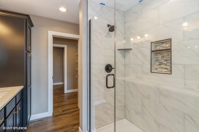 bathroom with vanity, hardwood / wood-style flooring, and a shower with shower door