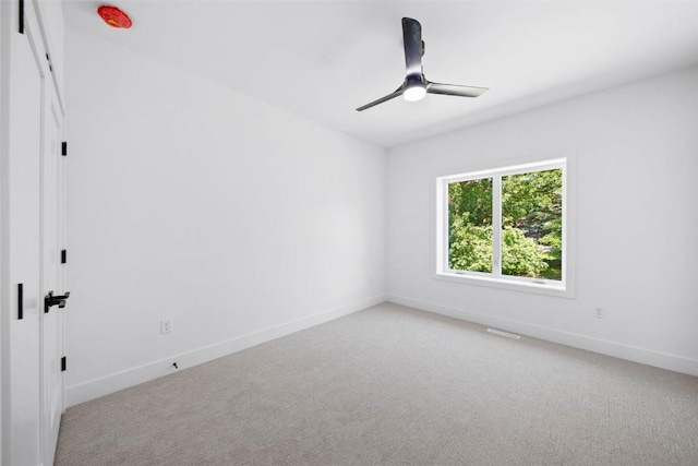 spare room with light colored carpet and ceiling fan