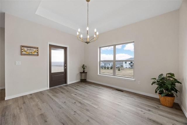 entryway featuring an inviting chandelier and light hardwood / wood-style flooring