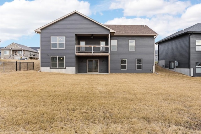 rear view of property with a balcony and a yard