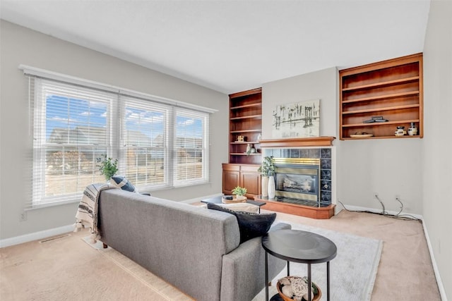 living room featuring a fireplace, built in features, plenty of natural light, and light colored carpet