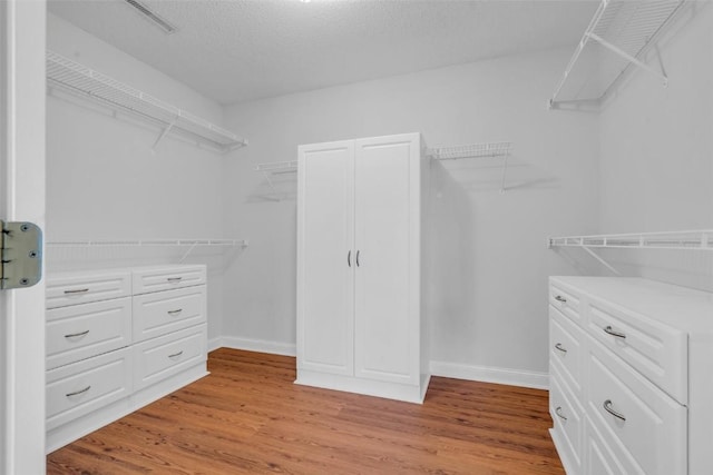 walk in closet featuring light hardwood / wood-style flooring