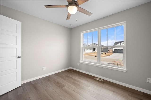 spare room featuring wood-type flooring and ceiling fan