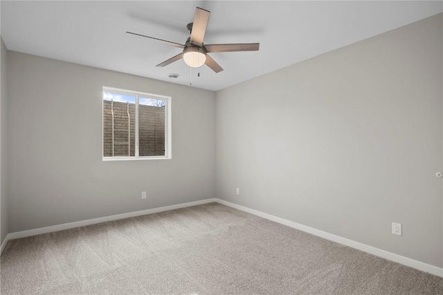 carpeted spare room featuring ceiling fan