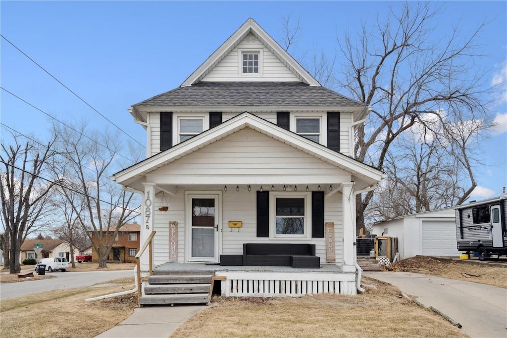 view of front of home with an outbuilding, a garage, and a porch