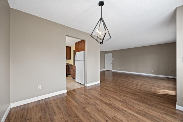 interior space with hardwood / wood-style flooring, a textured ceiling, and an inviting chandelier