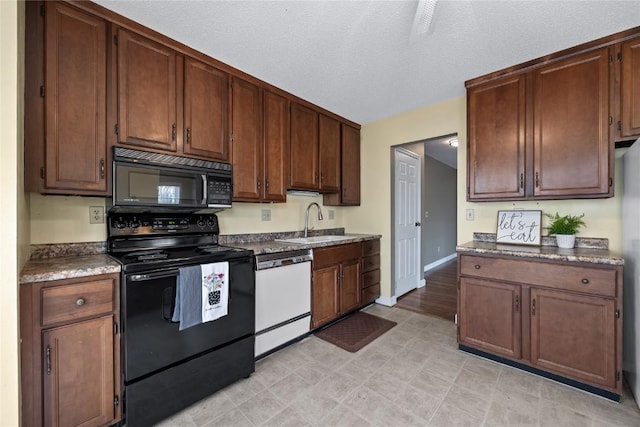 kitchen with sink, a textured ceiling, and black appliances