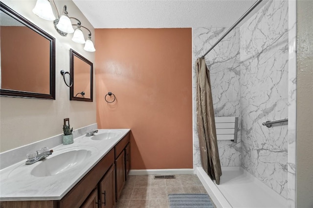 bathroom featuring a shower with curtain, vanity, and a textured ceiling