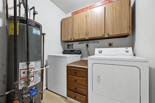 washroom featuring cabinets, washing machine and dryer, water heater, and a textured ceiling